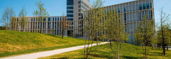 City campus building with grass at the front and blue sky.