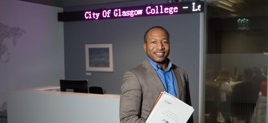 Business student holding a folder in city campus.